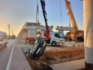 Bursa'da kontrolden çıkan otomobil üst geçit inşaatına düştü