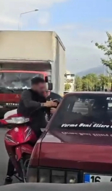 Otomobil sürücüsü dışarıya çıkmayınca motosikletli camdan içeri girmeye çalıştı